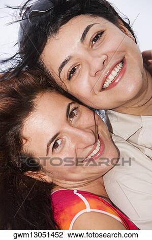 Stock Image - Portrait of two mid adult women smiling. Fotosearch