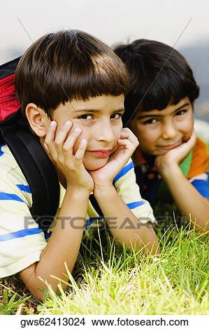 Portrait of two schoolboys lying on the grass View Large Photo Image Picture - Portrait of two schoolboys lying on the grass. Fotosearch