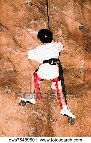 Rear view of a boy climbing a wall View Large Photo Image Stock Image - Rear view of a boy climbing a wall. Fotosearch