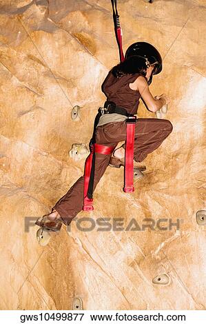 Rear view of a girl climbing a wall View Large Photo Image Stock Photo - Rear view of a girl climbing a wall. Fotosearch