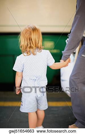 Rear view of a girl standing with her father at a railroad station platform, Rome, Italy View Large Photo Image Stock Image - Rear view of a girl standing with her father at a railroad station platform, Rome, Italy. Fotosearch