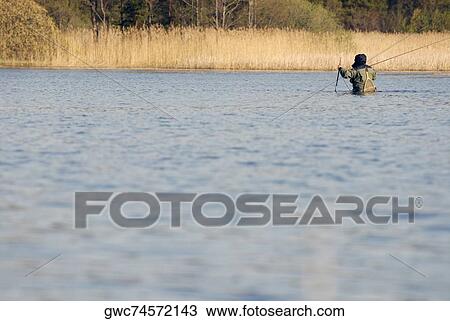 Rear view of a man fishing in the river View Large Photo Image Stock Image - Rear view of a man fishing in the river. Fotosearch