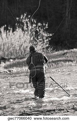 Rear view of a man fishing in the river View Large Photo Image Stock Image - Rear view of a man fishing in the river. Fotosearch