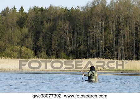 Rear view of a man fishing in the river View Large Photo Image Stock Image - Rear view of a man fishing in the river. Fotosearch