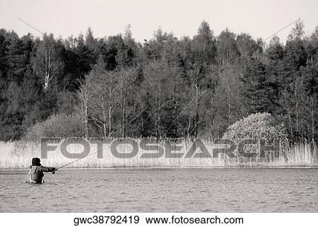 Rear view of a man fishing in the river View Large Photo Image Stock Photo - Rear view of a man fishing in the river. Fotosearch