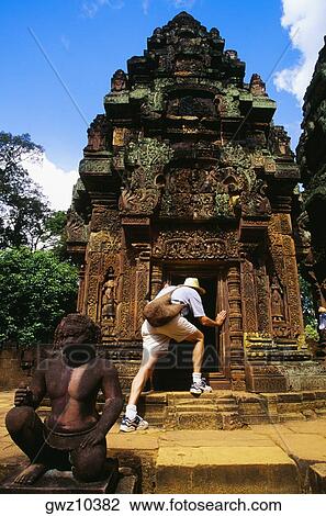 Rear view of a man peeking into a temple, Banteay Srei, Angkor, Siem Reap, Cambodia View Large Photo Image Stock Image - Rear view of a man peeking into a temple, Banteay Srei, Angkor, Siem Reap, Cambodia. Fotosearch