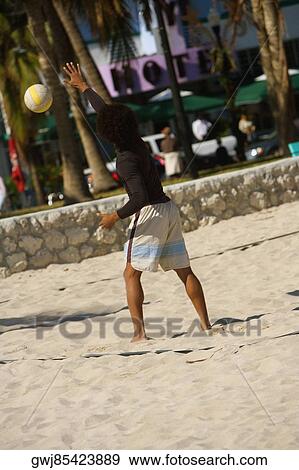Rear view of a man playing volleyball on the beach, Miami Beach, Florida, USA View Large Photo Image Stock Photo - Rear view of a man playing volleyball on the beach, Miami Beach, Florida, USA. Fotosearch