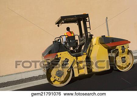 Rear view of a man sitting on a steamroller View Large Photo Image Stock Photograph - Rear view of a man sitting on a steamroller. Fotosearch