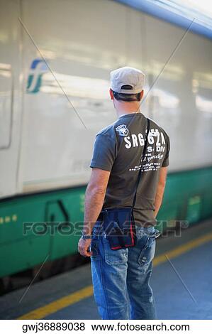 Rear view of a man standing at a railroad station, Rome, Italy View Large Photo Image Stock Photo - Rear view of a man standing at a railroad station, Rome, Italy. Fotosearch
