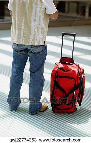 Rear view of a man standing with luggage beside him, Madrid, Spain View Large Photo Image Stock Image - Rear view of a man standing with luggage beside him, Madrid, Spain. Fotosearch
