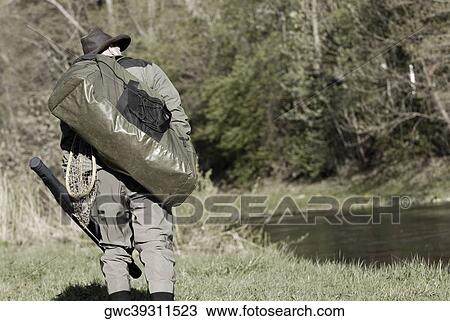 Rear view of a man walking with a bag on his back View Large Photo Image Stock Image - Rear view of a man walking with a bag on his back. Fotosearch