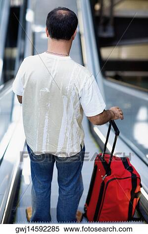 Stock Photography - Rear view of a person standing on an escalator, Madrid, Spain. Fotosearch