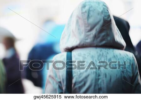 Rear view of a person wearing a raincoat View Large Photo Image Stock Photography - Rear view of a person wearing a raincoat. Fotosearch