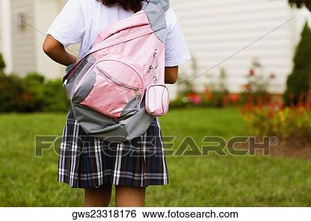 Rear view of a schoolgirl carrying a schoolbag View Large Photo Image Stock Photograph - Rear view of a schoolgirl carrying a schoolbag. Fotosearch