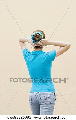 Rear view of a teenage girl standing with her hands behind her head View Large Photo Image Stock Image - Rear view of a teenage girl standing with her hands behind her head. Fotosearch