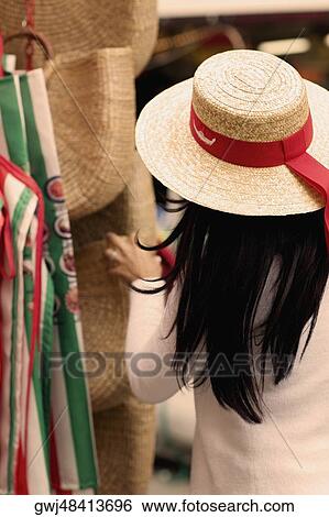 Stock Photograph - Rear view of a woman standing at a market stall. Fotosearch