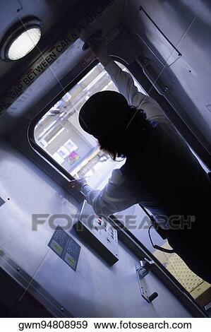 Rear view of a woman standing near a door in a train View Large Photo Image Stock Photo - Rear view of a woman standing near a door in a train. Fotosearch