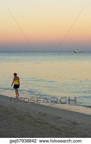 Rear view of a woman walking on the beach View Large Photo Image Stock Image - Rear view of a woman walking on the beach. Fotosearch