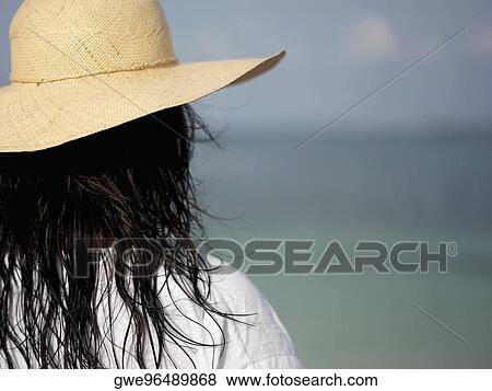 Rear view of a young woman wearing a sun hat View Large Photo Image Stock Photo - Rear view of a young woman wearing a sun hat. Fotosearch
