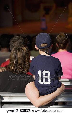 Rear view of four people watching stage performance View Large Photo Image Stock Image - Rear view of four people watching stage performance. Fotosearch