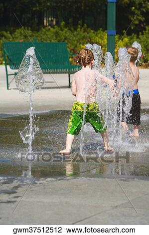Rear view of two boys in a fountain View Large Photo Image Stock Image - Rear view of two boys in a fountain. Fotosearch