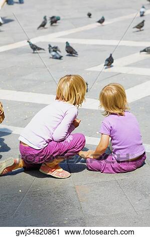 Rear view of two girls looking at pigeons, Venice, Veneto, Italy View Large Photo Image Stock Image - Rear view of two girls looking at pigeons, Venice, Veneto, Italy. Fotosearch