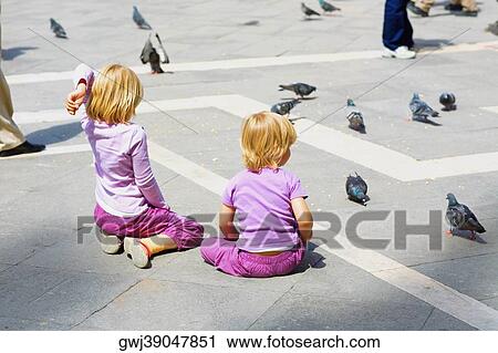 Rear view of two girls looking at pigeons, Venice, Veneto, Italy View Large Photo Image Stock Image - Rear view of two girls looking at pigeons, Venice, Veneto, Italy. Fotosearch
