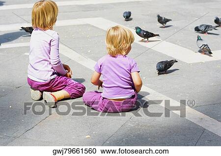 Rear view of two girls looking at pigeons, Venice, Veneto, Italy View Large Photo Image Stock Image - Rear view of two girls looking at pigeons, Venice, Veneto, Italy. Fotosearch