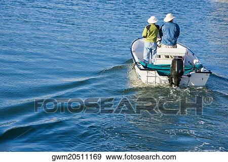 Stock Photo - Rear view of two people in a motorboat. Fotosearch