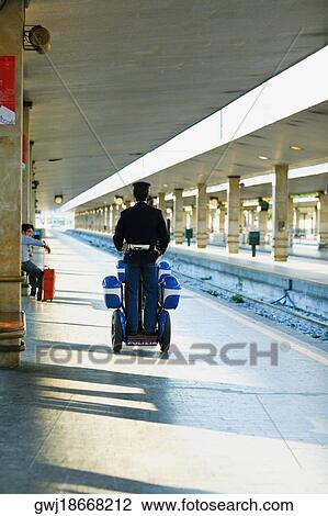Rear view of two policemen traveling on scooters at a railroad station platform, Rome, Italy View Large Photo Image Stock Image - Rear view of two policemen traveling on scooters at a railroad station platform, Rome, Italy. Fotosearch