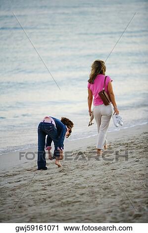 Rear view of two women walking on the beach View Large Photo Image Stock Image - Rear view of two women walking on the beach. Fotosearch