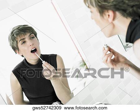 Reflection of a mature woman applying lipstick View Large Photo Image Stock Photo - Reflection of a mature woman applying lipstick. Fotosearch