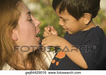 Side profile of a boy and his mother playing View Large Photo Image Stock Photograph - Side profile of a boy and his mother playing. Fotosearch