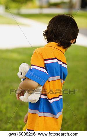 Side profile of a boy holding a teddy bear View Large Photo Image Stock Photograph - Side profile of a boy holding a teddy bear. Fotosearch
