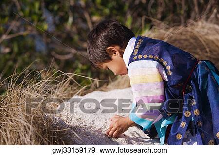 Side profile of a boy playing in sand View Large Photo Image Stock Photo - Side profile of a boy playing in sand. Fotosearch
