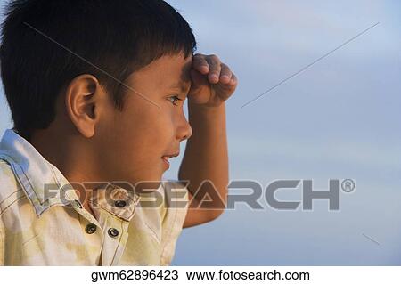 Side profile of a boy shielding his eyes View Large Photo Image Stock Image - Side profile of a boy shielding his eyes. Fotosearch