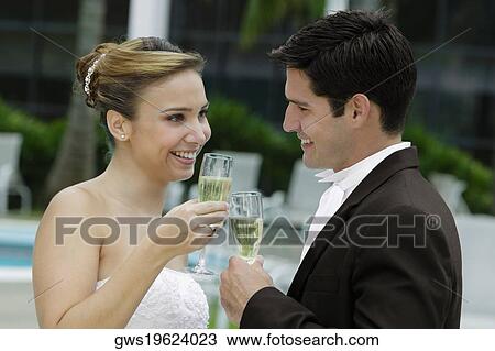 Side profile of a bride and her groom toasting with champagne flutes View Large Photo Image Stock Image - Side profile of a bride and her groom toasting with champagne flutes. Fotosearch