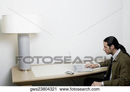 Side profile of a businessman using a laptop View Large Photo Image Stock Image - Side profile of a businessman using a laptop. Fotosearch