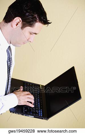 Side profile of a businessman using a laptop View Large Photo Image Stock Photo - Side profile of a businessman using a laptop. Fotosearch