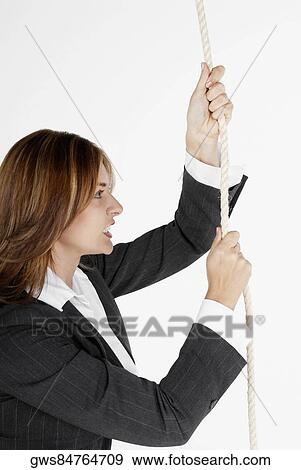 Side profile of a businesswoman holding a rope and clenching her teeth View Large Photo Image Stock Photo - Side profile of a businesswoman holding a rope and clenching her teeth. Fotosearch