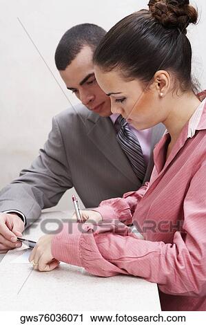 Side profile of a businesswoman writing with a businessman holding a credit card beside her View Large Photo Image Stock Image - Side profile of a businesswoman writing with a businessman holding a credit card beside her. Fotosearch