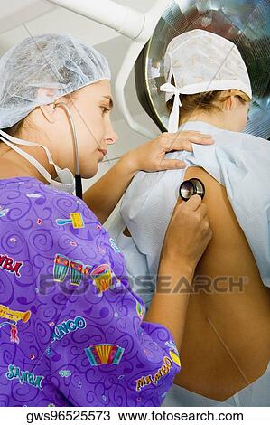 Side profile of a female doctor examining a female patient with a stethoscope View Large Photo Image Stock Image - Side profile of a female doctor examining a female patient with a stethoscope. Fotosearch