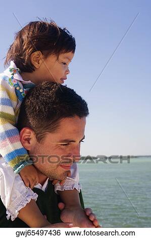 Side profile of a girl riding piggyback on her father View Large Photo Image Stock Photograph - Side profile of a girl riding piggyback on her father. Fotosearch