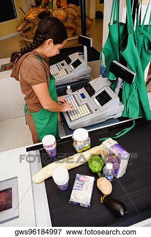 Side profile of a girl using a cash register at the checkout counter View Large Photo Image Stock Photo - Side profile of a girl using a cash register at the checkout counter. Fotosearch