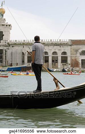 Side profile of a gondolier standing on a gondola, Venice, Veneto, Italy View Large Photo Image Stock Photograph - Side profile of a gondolier standing on a gondola, Venice, Veneto, Italy. Fotosearch