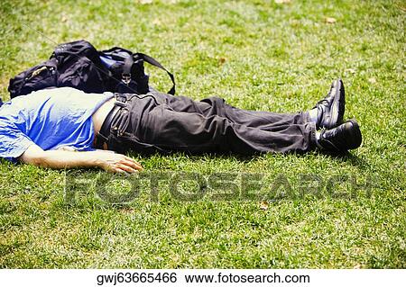 Side profile of a man lying on the grass View Large Photo Image Stock Photograph - Side profile of a man lying on the grass. Fotosearch