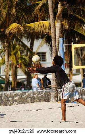 Side profile of a man playing volleyball on the beach, Miami, Florida, USA View Large Photo Image Stock Photograph - Side profile of a man playing volleyball on the beach, Miami, Florida, USA. Fotosearch