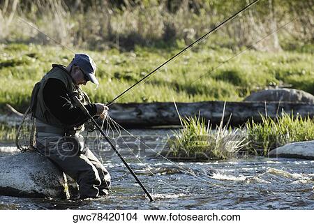 Side profile of a mature man fishing in the river View Large Photo Image Picture - Side profile of a mature man fishing in the river. Fotosearch
