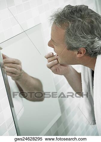 Side profile of a mature man touching his face in a mirror View Large Photo Image Stock Photography - Side profile of a mature man touching his face in a mirror. Fotosearch