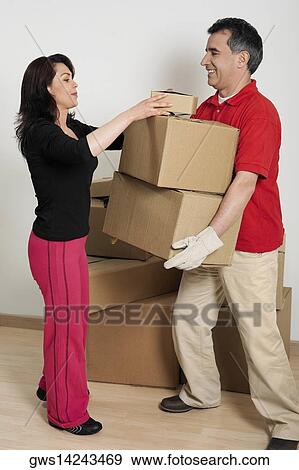 Side profile of a mid adult woman helping a mid adult man hold cardboard boxes View Large Photo Image Stock Photo - Side profile of a mid adult woman helping a mid adult man hold cardboard boxes. Fotosearch